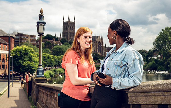 Students by the river in front of Worcester Cathedral
